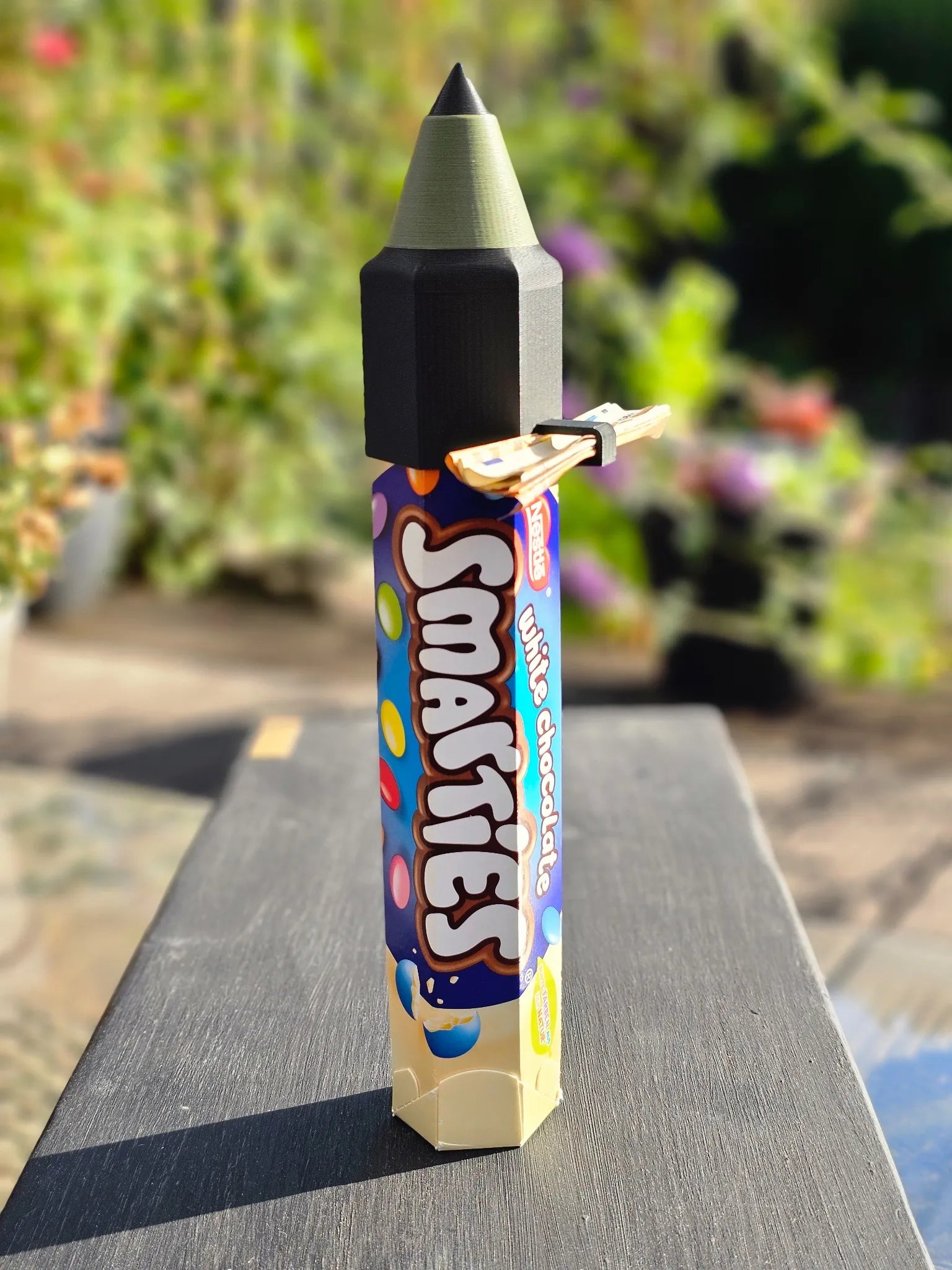 Stylische Rakete mit olivgrüner Spitze auf einer Smarties-Rolle – ungewöhnlich cooles Geschenk zur Einschulung