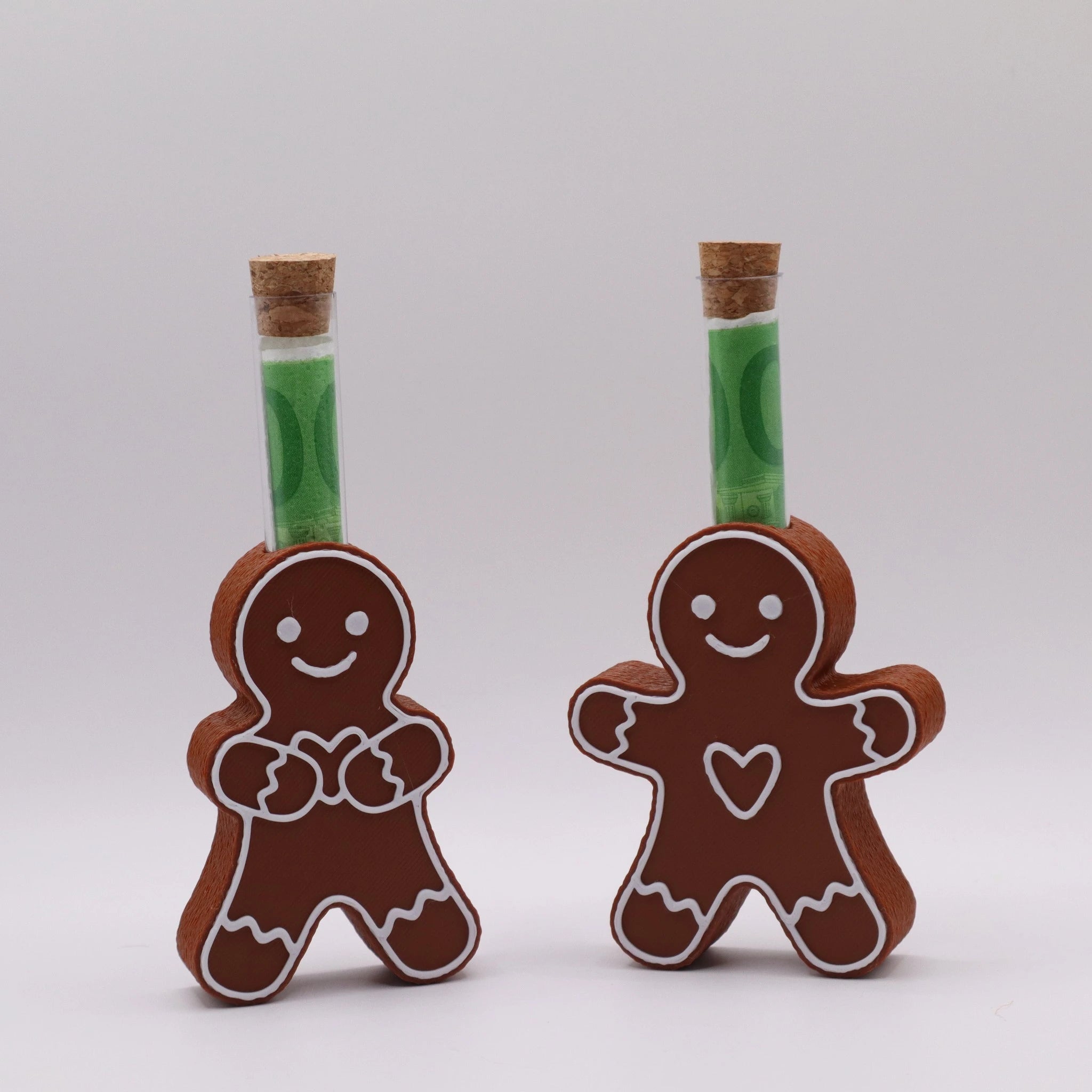 Zwei süße Lebkuchenfiguren mit Reagenzglas – GingerHug Collection von Mudivo. Perfekt als Weihnachts-Geldgeschenk in Braun mit weißem Zuckerguss.