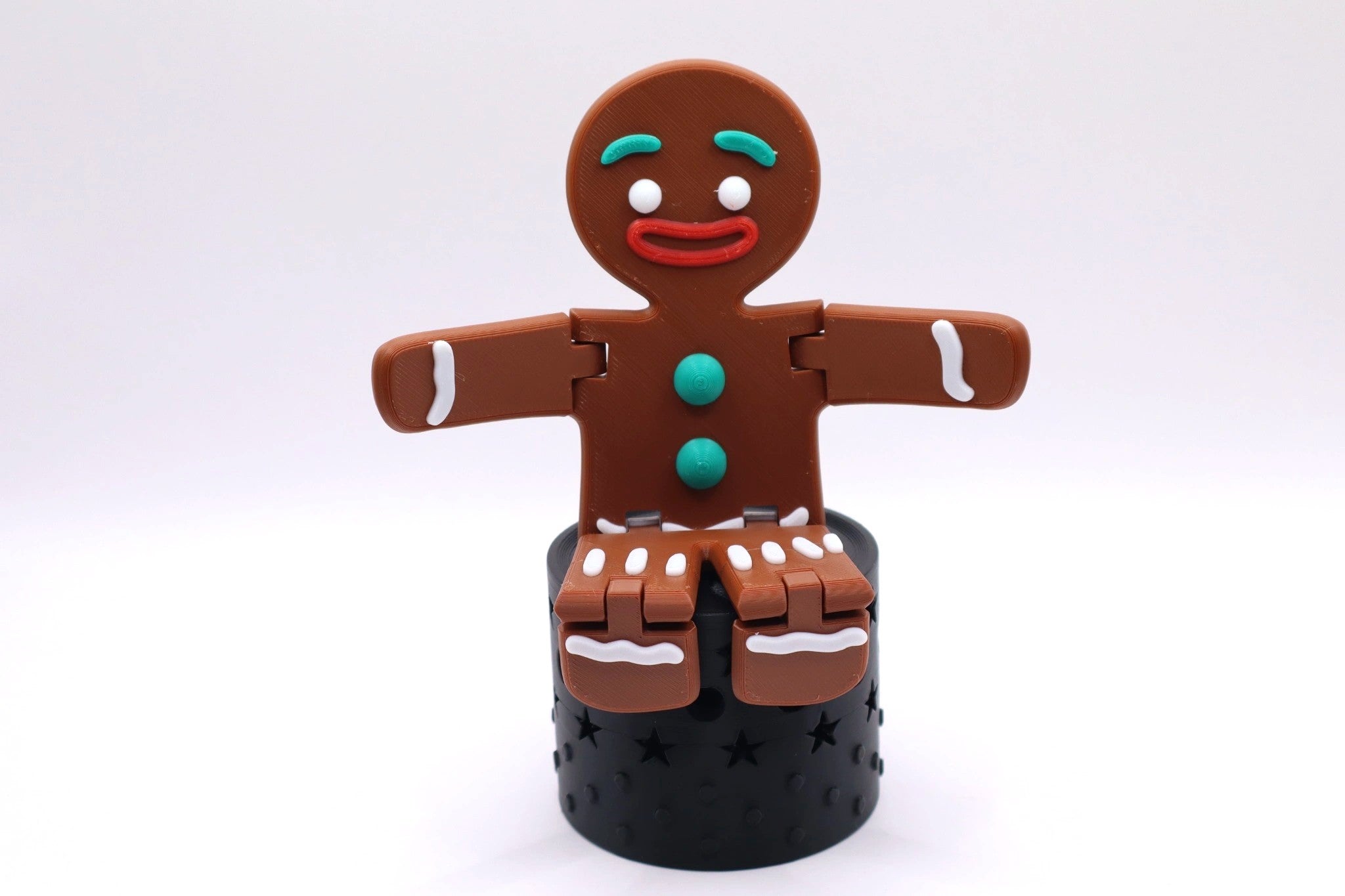 Mudivo GingerMood – bewegliche Lebkuchenfigur sitzend auf schwarzem Podest. Fröhliche Weihnachtsdeko mit Stil und Herz. 🎄✨
