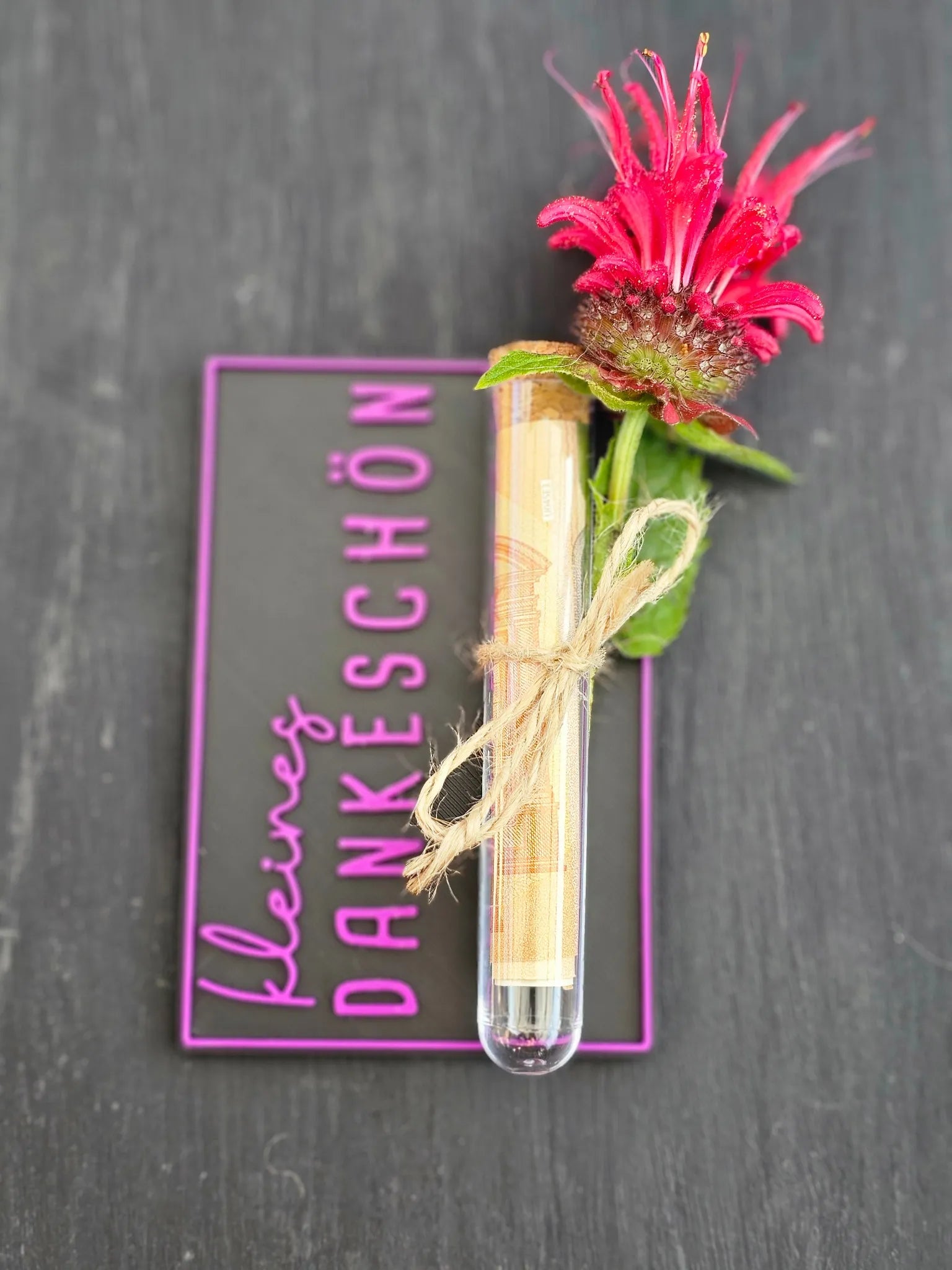 Schwarze Karte mit rosa Schriftzug „kleines DANKESCHÖN“, dekorativem Reagenzglas und Blume als Geldgeschenk