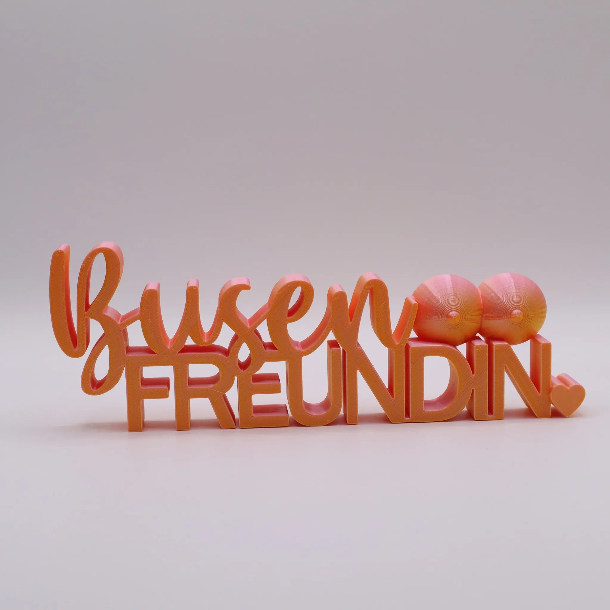 3D-gedrucktes Deko-Statement in Pink mit goldenen Akzenten, Schriftzug Busenfreundin, verziert mit Busen-Symbolen und Herz